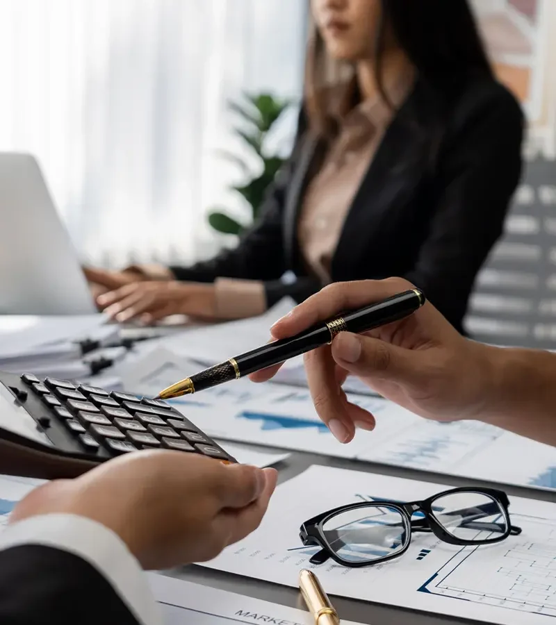 Team reviewing infrastructure project plans with detailed financial models, coordinating multiple stakeholders for successful project delivery.